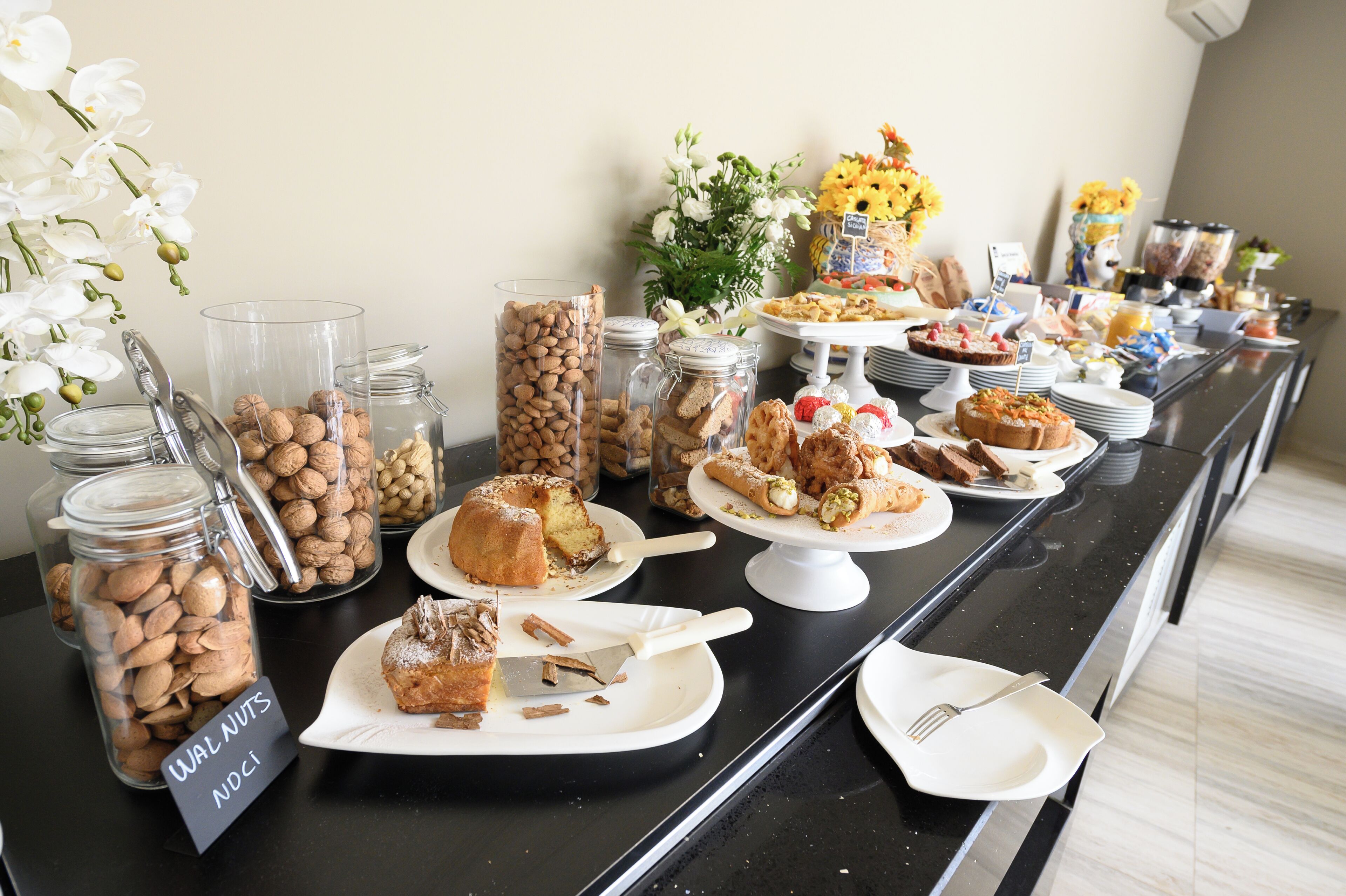 A buffet table with various food items, including pastries, nuts, and desserts.