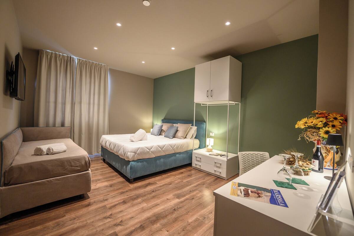 A modern bedroom with a bed, a sofa, a desk, and a cabinet.