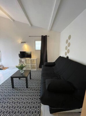 Relax in this stylish living space with a sofa, coffee table, and flat-screen TV.