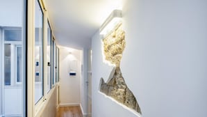 A hallway with a stone wall feature and a door at the end.