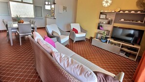 A living room with a sofa, chairs, a TV, and a dining area with a table and chairs. - Villa Cécia - Four Bedroom Villa, Sleeps 8 (Les Trois-Îlets)