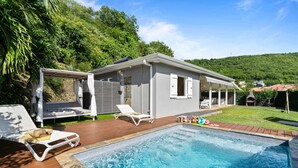 A house with a swimming pool, outdoor seating, and a covered patio.
