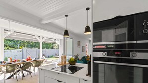 A modern kitchen with a built-in oven and a dining area with a table and chairs.