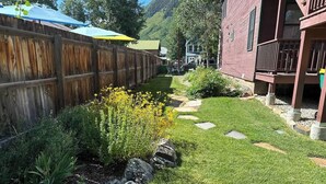 A well-maintained garden with a wooden fence, a pathway, and a building with a balcony.