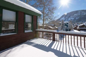 A wooden building with a snow-covered balcony, a mountain in the background, and a clear sky. - Alpenglow- Great location in Town of Crested Butte (Crested Butte)
