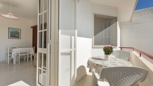 A balcony with a table and chairs, a potted plant, and a dining area with a table and chairs. - 3796 Casa Solero by Barbarhouse (Melendugno)