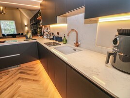 Una cucina moderna con una grande isola, un rubinetto in rame e una macchina da caffè.