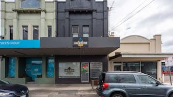 A building with a sign for 'Leak Detection Experts' and a list of services including blockages, inspections, and gas.