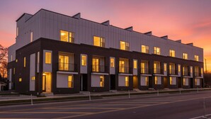 A modern multi-story building with a flat roof, large windows, and a clean, contemporary design.