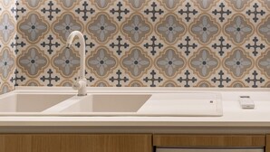 A kitchen with a Bosch dishwasher, a double sink, and a patterned backsplash. - Via Concezione a Montecalvario 19 - Camera 3 (Naples)