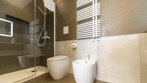 A modern bathroom with a glass shower enclosure, a toilet, and a pedestal sink. - Via Concezione a Montecalvario 19 - Camera 3 (Naples)