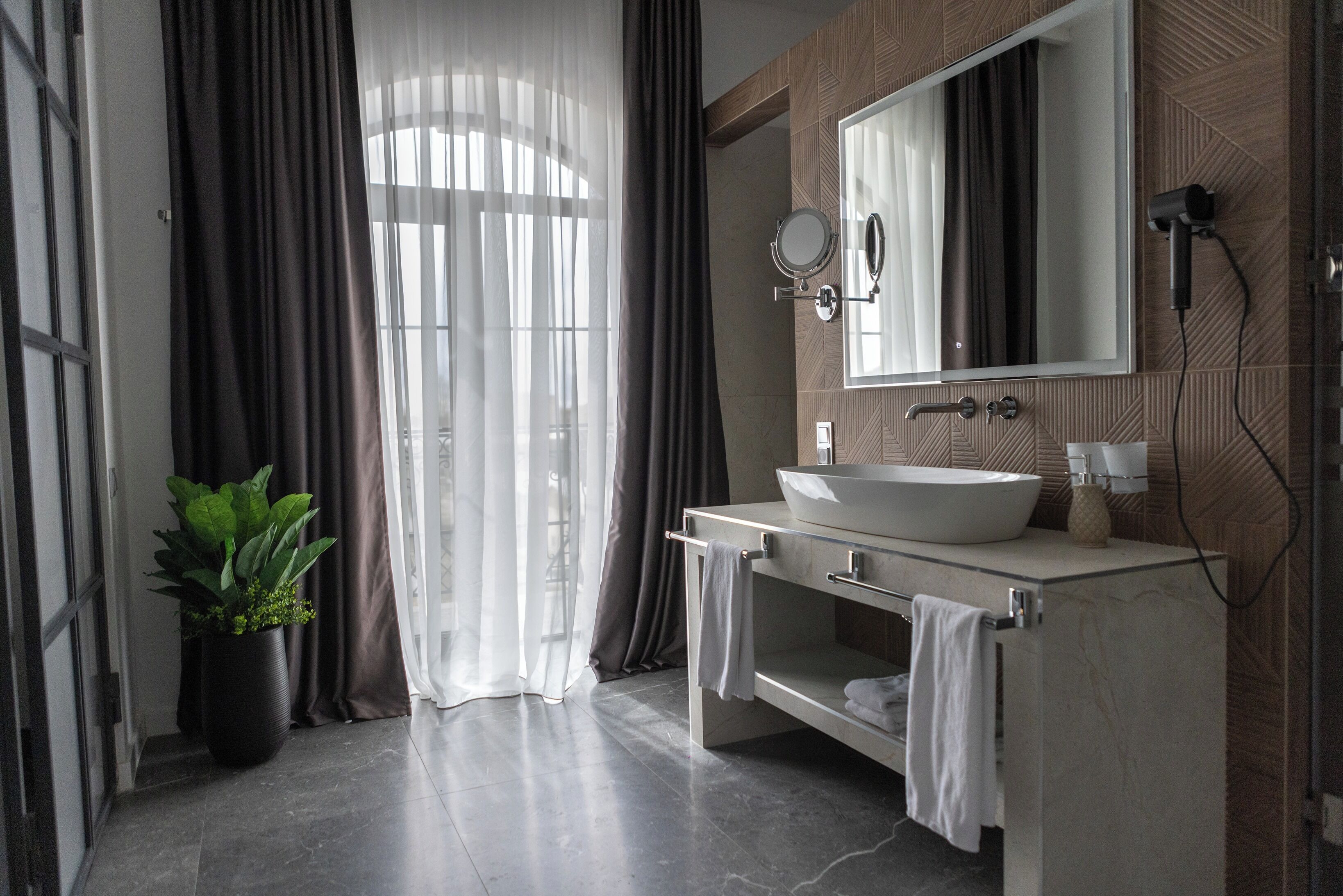 Ein modernes Badezimmer mit einem großen Spiegel, einem Waschbecken und einer Duschkabine.