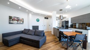 A modern living room with a sectional sofa, a dining area with a wooden table and chairs, and a kitchen with modern appliances. - Casa del Marchese del Grillo (Rome)