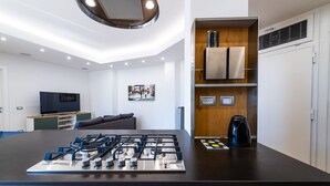 A modern kitchen with a gas stove, a coffee maker, and a built-in oven. - Casa del Marchese del Grillo (Rome)