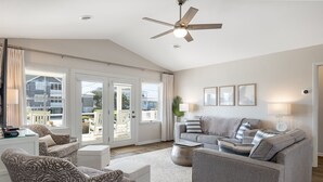 A spacious living room with a grey sofa set, patterned armchairs, and a ceiling fan. - Dot's Spot, Almost Oceanfront House in Emerald Isle, NC! (Atlantic Beach)