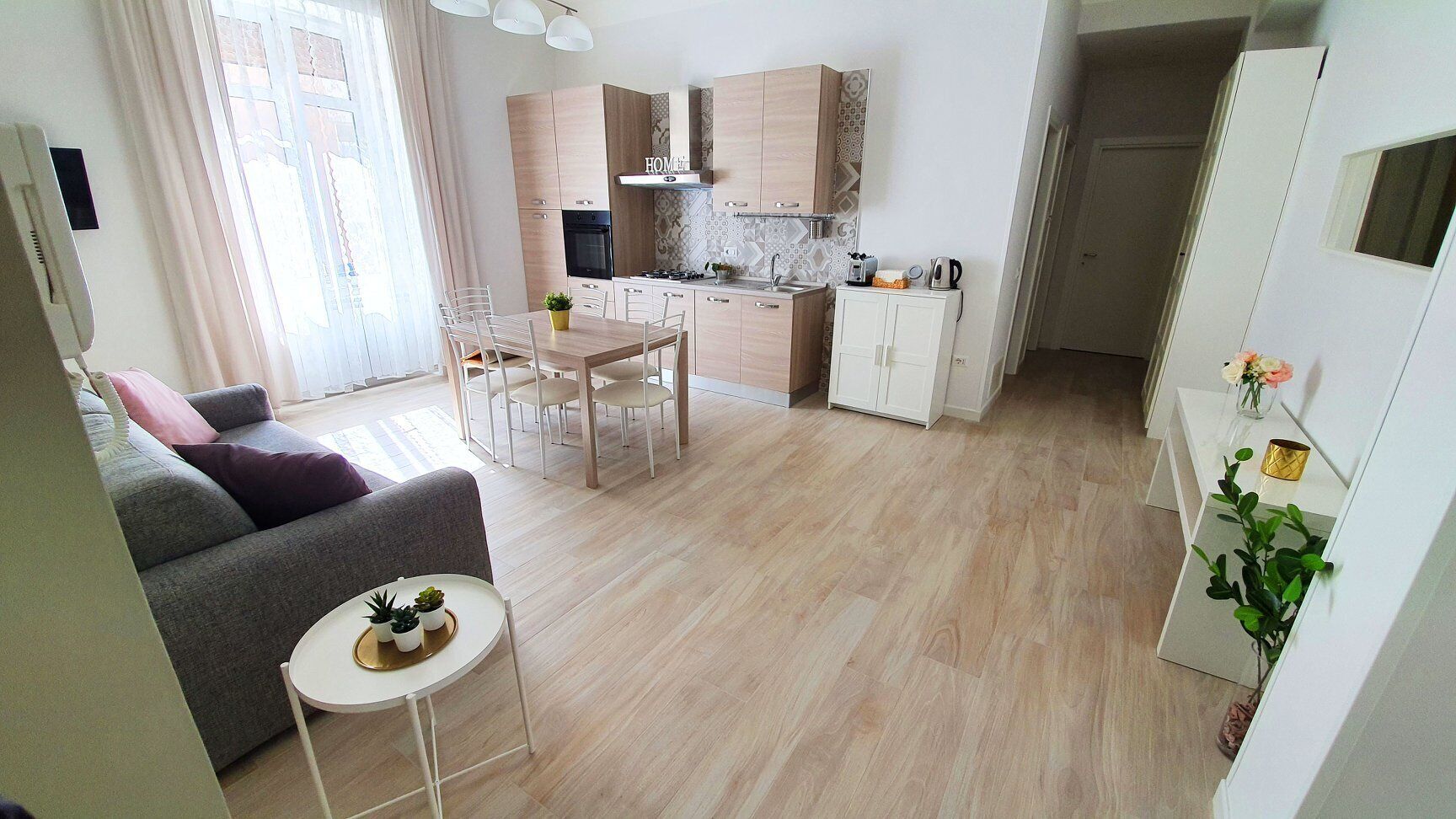 Un appartement moderne comprenant un espace de vie, un coin repas et une cuisine.