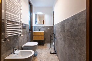 Une petite salle de bain avec un lavabo blanc, des toilettes et un meuble en bois.