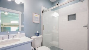 A bathroom with a sink, toilet, and glass-enclosed shower.