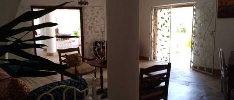 Una habitación amplia con techo alto, una cama, una silla, una mesa y un farol colgante.