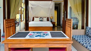 Ein Zimmer mit einem Bett, einem Holztisch mit Unterlage und einem Sofa.