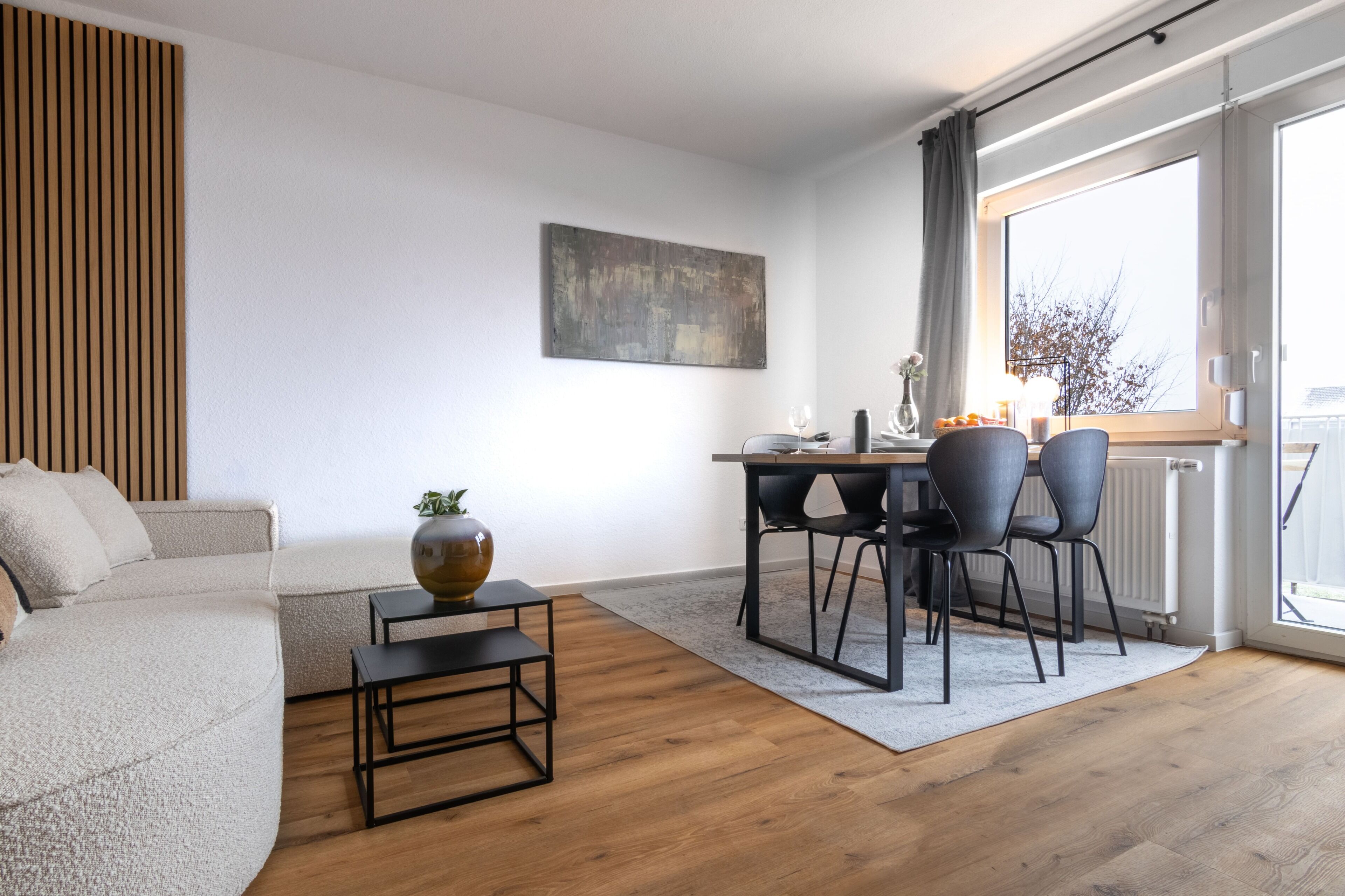 Ein modernes Wohnzimmer mit einer Couch, einem Couchtisch und einem Essbereich mit Stühlen und einem Tisch.