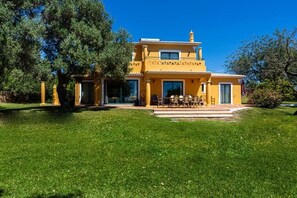 Un bâtiment jaune doté d’un patio et de places assises extérieures.