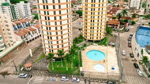 A high-rise building with a rooftop pool and a tennis court. - Beira Mar Caragua (Caraguatatuba)