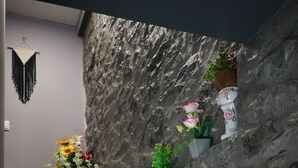 Kivimuuri, jossa on puinen portaikko ja ruukuissa olevia kasveja.