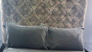 A bed with a patterned headboard, grey pillows, and a blanket. - Almond Tree Studio - Modern A/C Apartment w/2 Queen beds in St. James (holetown)