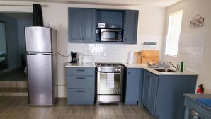 A compact kitchen with a refrigerator, stove, microwave, and sink. - Almond Tree Studio - Modern A/C Apartment w/2 Queen beds in St. James (holetown)