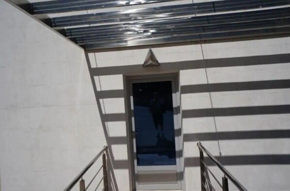 A staircase leading to a door with a triangular architectural feature above it. - Dobrota, View, Pool, Luxury, Sea (Kotor)