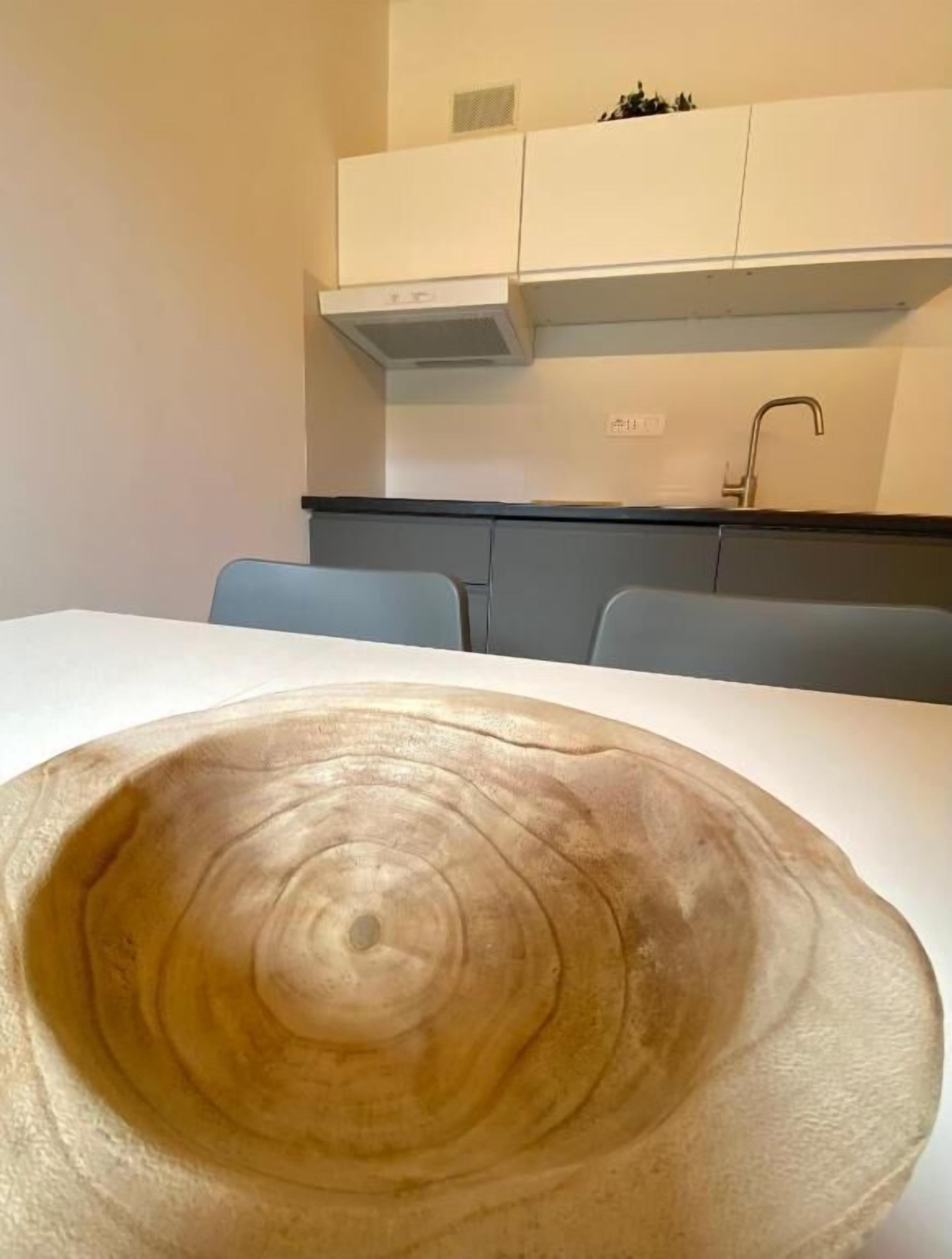 Une table à manger agrémentée d’un grand saladier en bois placé au centre.