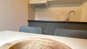 Une table à manger agrémentée d’un grand saladier en bois placé au centre.