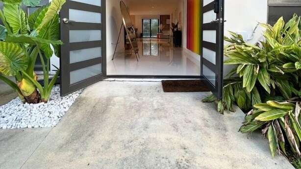 A modern house with a large open doorway leading to a spacious interior. - Super Stylish 4BR Retreat in the Heart of Las Olas (Fort Lauderdale)
