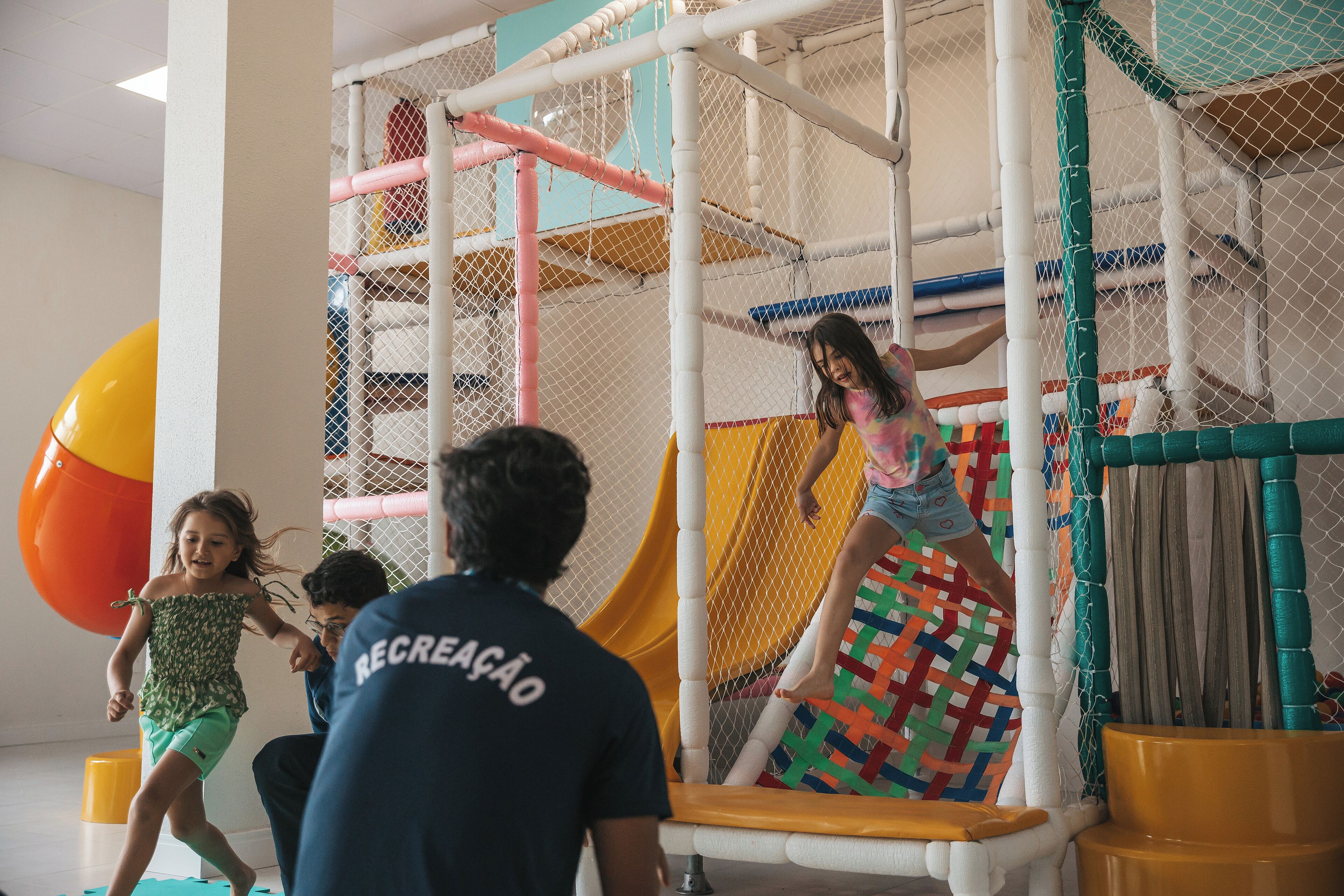 A play area with a slide and netted climbing structures.