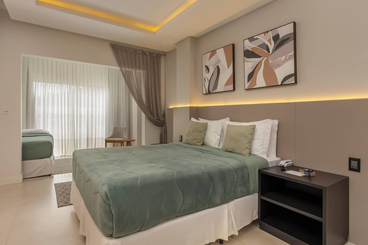 Um quarto moderno com uma cama grande, mesas de cabeceira e arte abstrata na parede.