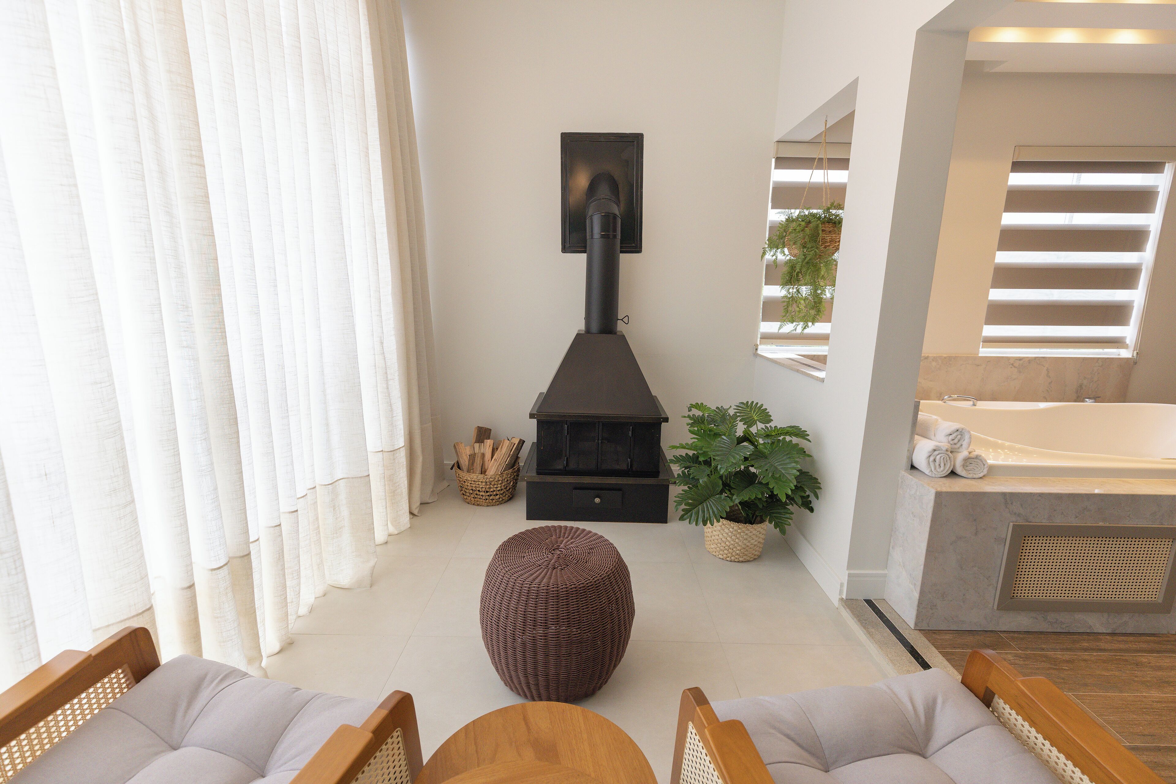 Uma sala de estar moderna com lareira, área de jantar e banheiro com banheira.