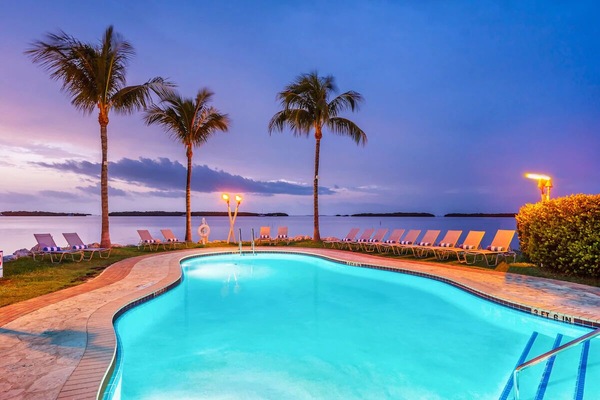 Sip something cool as the waterfront pool glows at dusk.