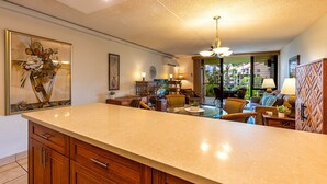 Uma cozinha espaçosa com uma ilha grande, armários de madeira e uma área de refeições com cadeiras e mesa.