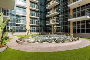 Stunning building with a glass facade, surrounded by lush greenery and a unique conservatory.