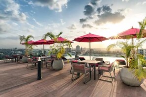 Enjoy a city view from our outdoor terrace, featuring comfortable seating and lush greenery.