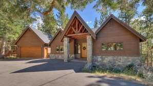 A cabin with a stone foundation, wooden exterior, and a garage. - Pet Friendly + Pool Table + Shuffle Board + Arcade Game (South Lake Tahoe)
