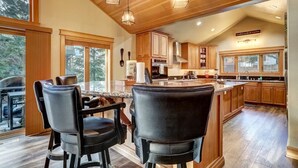 A modern kitchen with wooden cabinets, a large island, and pendant lighting. - Pet Friendly + Pool Table + Shuffle Board + Arcade Game (South Lake Tahoe)