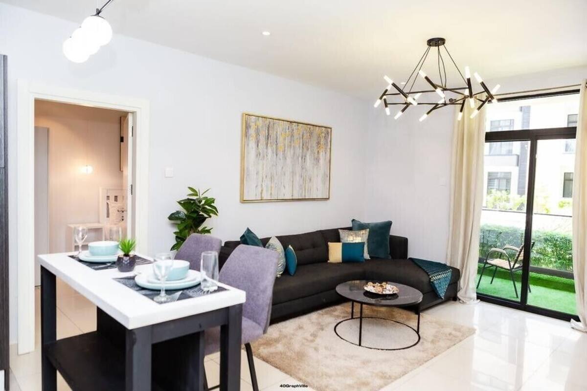 A modern living room with a sofa, coffee table, and dining area.