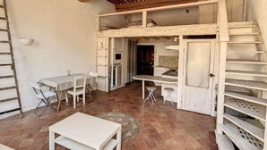 Ein rustikales Interieur mit Schlafzimmer im oberen Bereich, Essbereich und Küche.