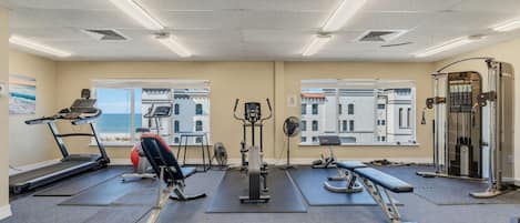 A gym with treadmills, weight machines, and a rowing machine.
