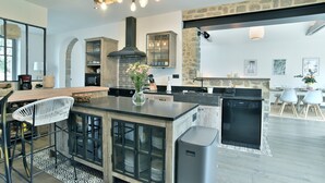 Una cocina moderna con una isla central, armarios empotrados y una pared de acento de piedra.