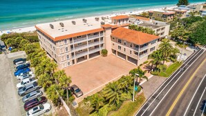 Un hôtel à plusieurs étages doté d’un parking, offrant une vue sur la plage et situé en bord de route.