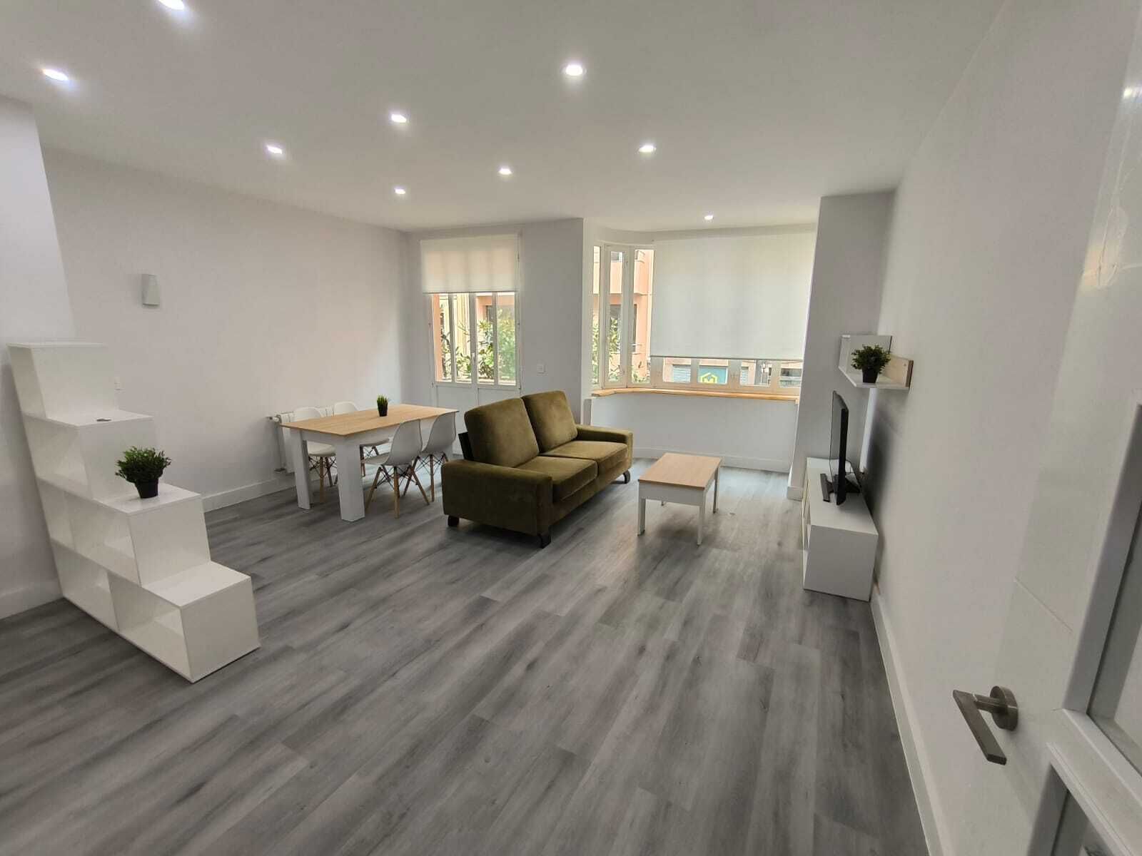 Een moderne woonkamer met een bank, een salontafel en een eethoek met een tafel en stoelen.
