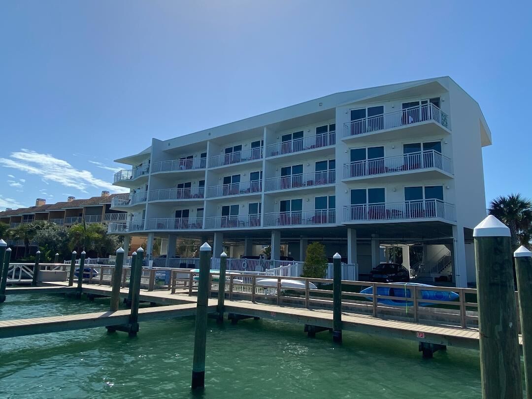 A multi-story hotel with balconies, a dock, and a pool.